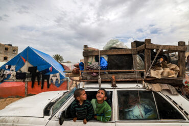 أطفال يجلسون داخل مركبة محملة بأشياء مؤمنة بحبل بينما يفر الناس من رفح في جنوب قطاع غزة في 13 شباط/ فبراير 2024 تصوير محمد عابد/ وكالة فرانس برس
